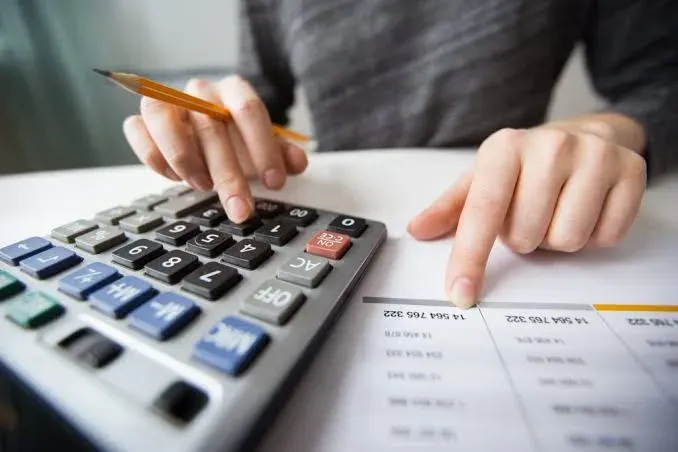 Detailed accounting work with a calculator and pen over financial documents