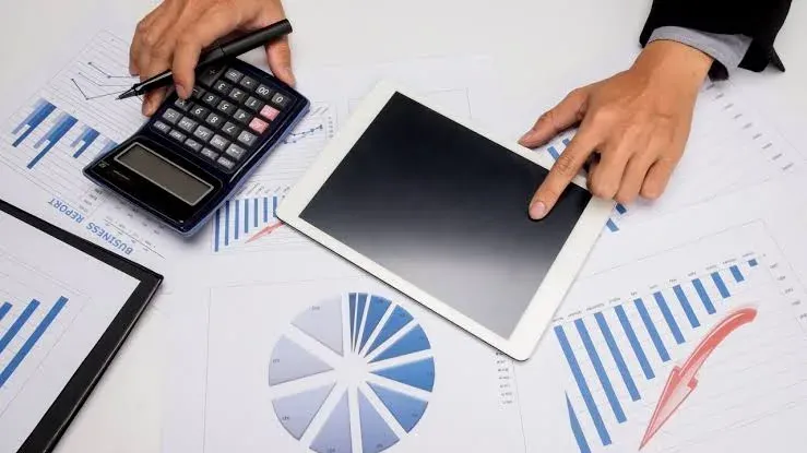 Detailed accounting work with a calculator, tablet and documents for social security processing