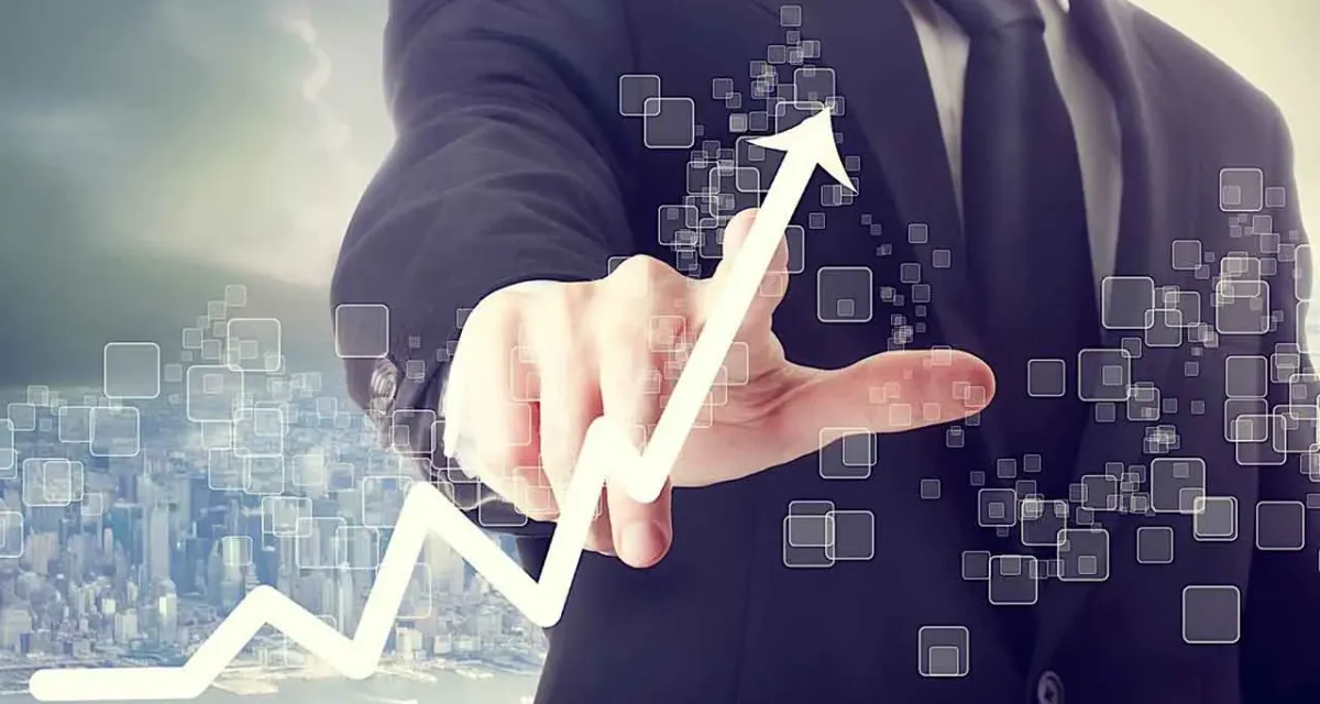 A businessperson pointing at a rising chart on digital displays